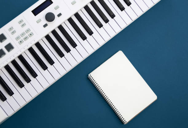 istock Piano keys and blank notepad on blue background, flat lay. 1458490447