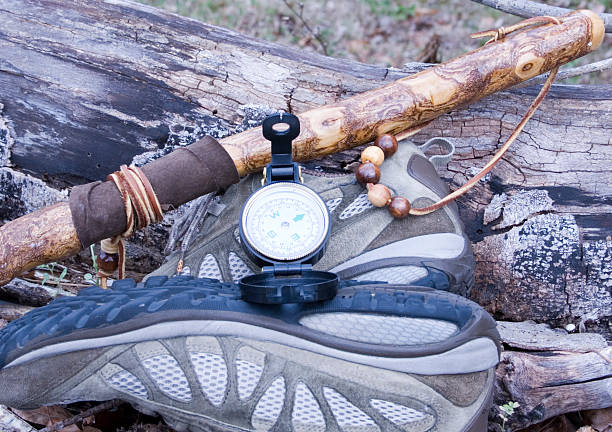 Compass with hicking shoes and walking stick stock photo