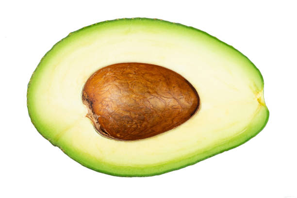 avocado in zwei hälften geschnitten mit knochen isoliert auf weiß. frisches gemüse. - avocado portion brown apple core stock-fotos und bilder