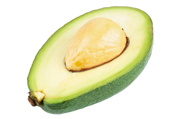avocado in zwei hälften geschnitten mit knochen isoliert auf weiß. frisches gemüse. - avocado portion brown apple core stock-fotos und bilder