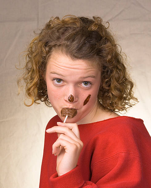 Teenage Girl Eating Chocolate stock photo