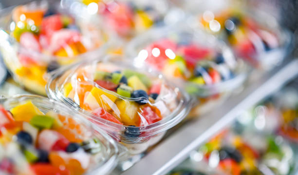 Boxes with pre-packaged fruit salads in a commercial fridge