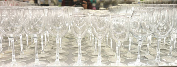 istock Rows of empty wine glasses close up. Glass goblets on the white table 1458497160