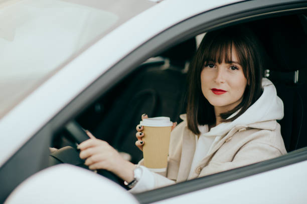istock Young woman using phone in the car 1458500637
