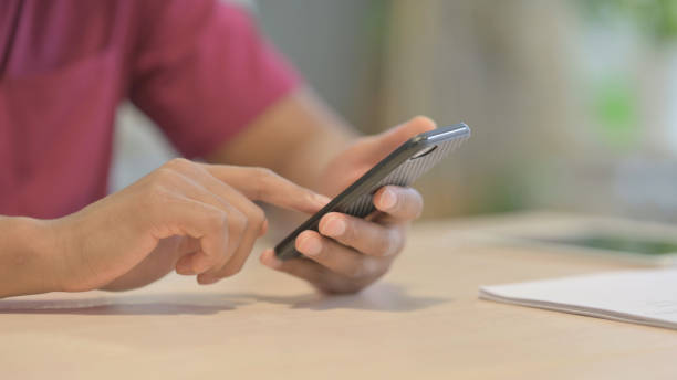 istock Close up of African Man Browsing Smartphone 1458502215