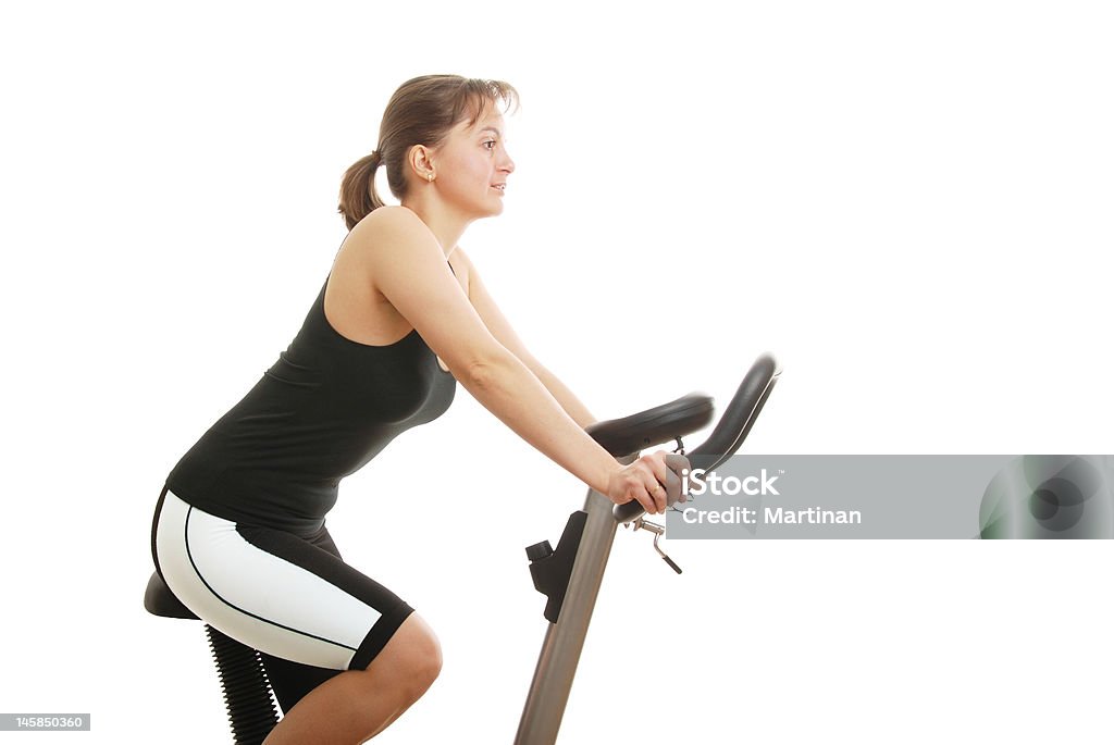 Isoliert Junge Frau sitzt auf einem spinning-Fahrrad - Lizenzfrei Aktiver Lebensstil Stock-Foto