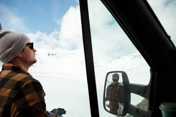 A men standing outside his camper flying a drone