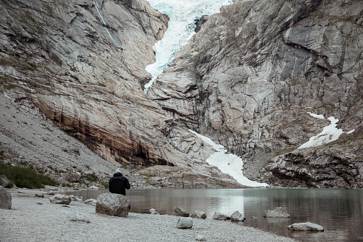 A guy watching the Briksdal glacier in Norway