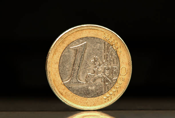 istock A very used one euro coin on black background 1458504550