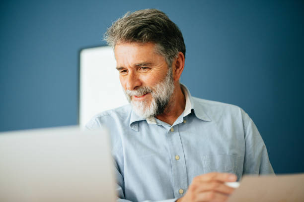 istock Happy Senior Businessman Working In His Modern Office 1458504949