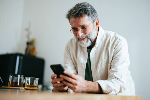 istock Happy Senior Businessman Using A Mobile Phone At Home 1458505677