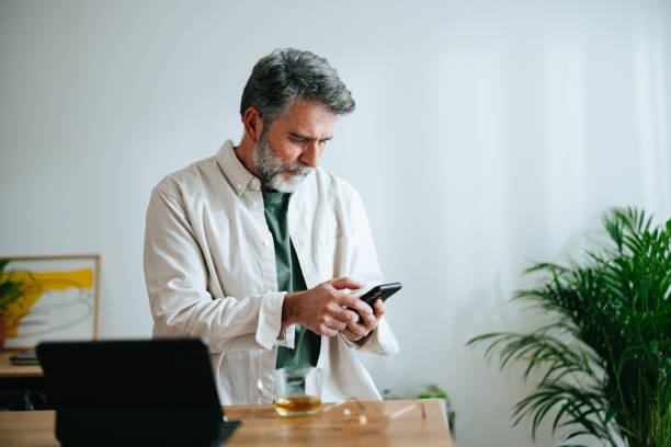 istock Happy Senior Businessman Using A Mobile Phone At Home 1458505681