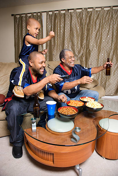 afroamerikanische familie watching tv - child american football football sport stock-fotos und bilder