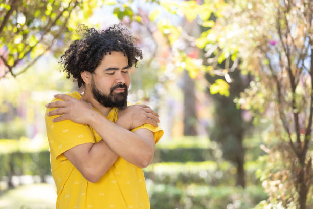 istock young Mexican man with beard and afro hugging himself, self love concept 1458506563
