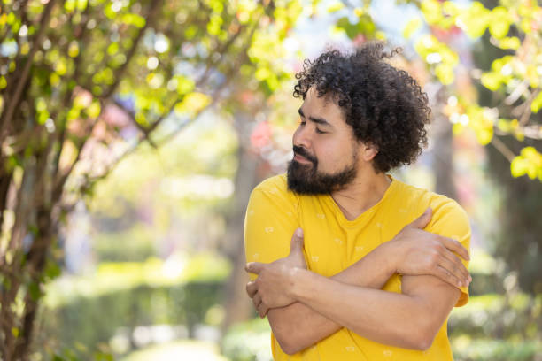 istock young Mexican man with beard and afro hugging himself, self love concept 1458506633