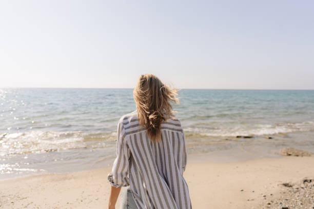 istock Young woman walking down the beach 1458509112