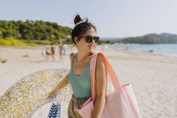 Photo of a smiling young woman enjoy sunny summer afternoon at the beach