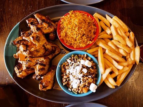 Grilled chicken wing with french fries rice and salad at glasgow scotland england uk