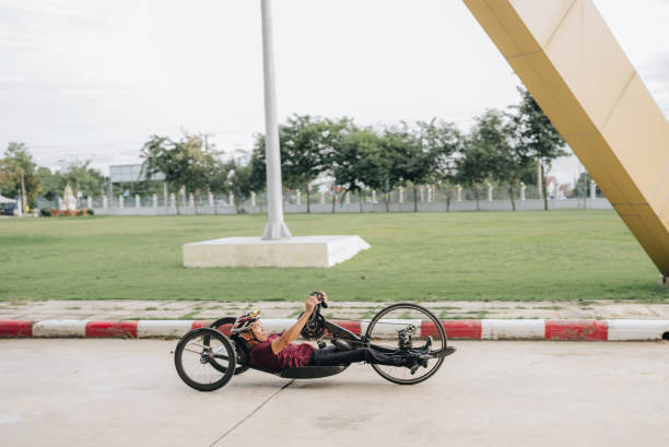 Athlete men with helmet riding his hand bike on a track.