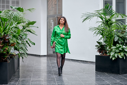 Portrait of Tamil ethnic woman in green dress. Walking in the studio corridor