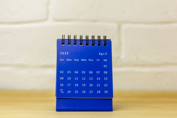 istock Desktop calendar for April 2023 on a wooden table. 1458515195