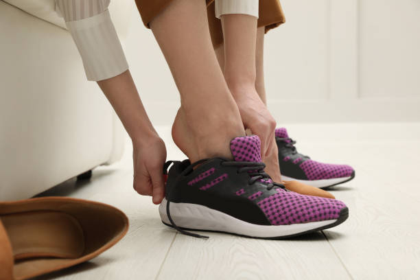 istock Woman changing shoes on sofa in office, closeup 1458516451