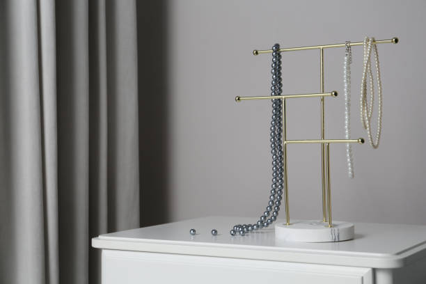 istock Interior element. Holder with set of luxurious jewelry on white table. Space for text 1458516601