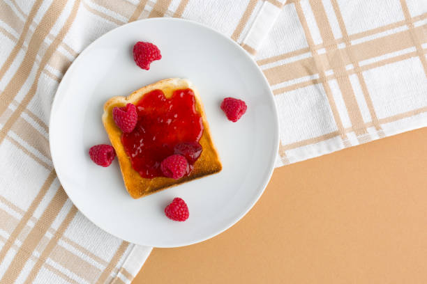 istock Cup of red tea and toasted bread with raspberry jam 1458517896