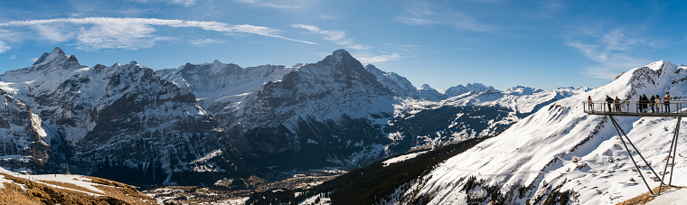 Grindelwald, Switzerland - February 22, 2020: Tourists enjoying beautiful view on Alps from viewing platform above Grindelwald in Switzerland during winter 2020