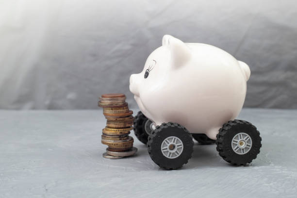 istock Piggy bank on wheels next to a stack of coins 1458518854