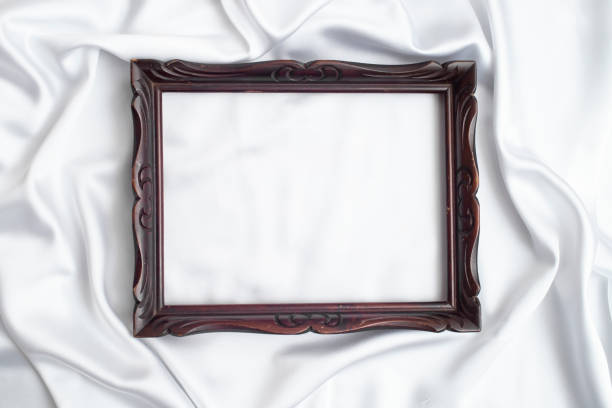 istock Brown wooden frame on white satin folds, 1458518919