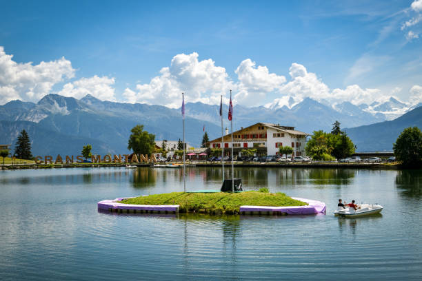 Young couple riding small pedalo on lake in Crans Montanta in Switzerland Crans-Montana, Switzerland - August 10, 2020: Young couple riding small pedalo on lake in Crans Montanta in Switzerland during summer 2020 crans montana stock pictures, royalty-free photos & images
