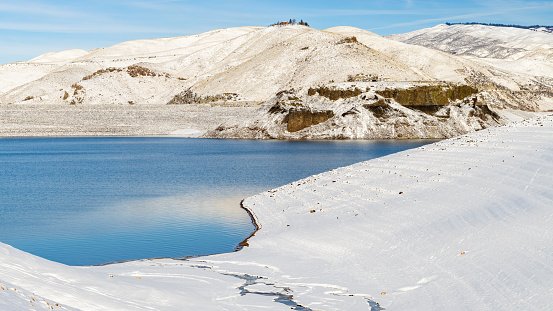 Snow covered shore of a low water reservoir in winter