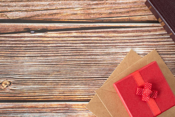 istock Red gift box and closed holy bible book on wooden table with copy space 1458522038