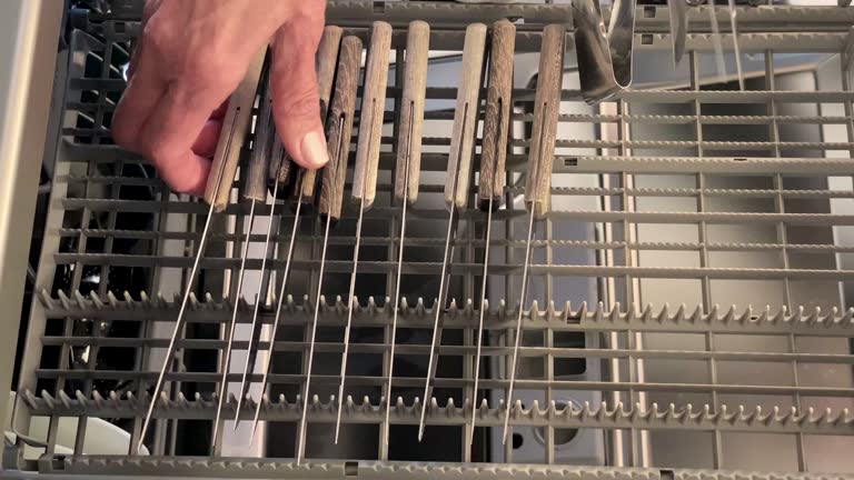 Woman taking out knives from the dishwasher