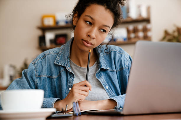 istock Black young woman working with laptop while sitting in cafe 1458532284