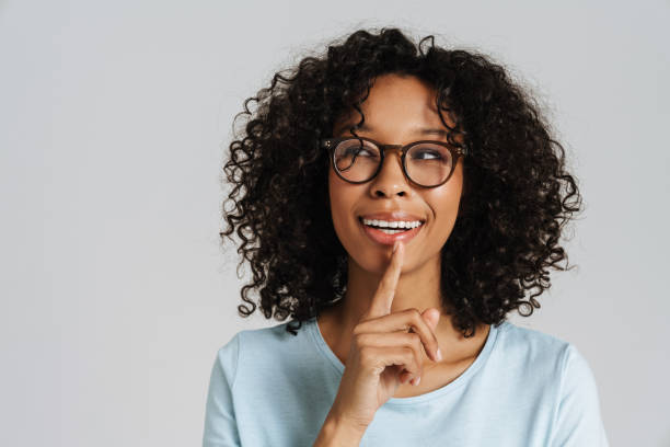 istock Black curly woman wearing eyeglasses smiling and looking aside 1458533752