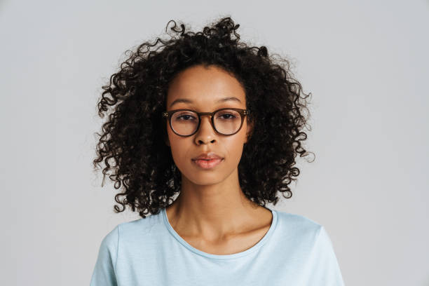 istock Black curly woman wearing eyeglasses posing and looking at camera 1458533753