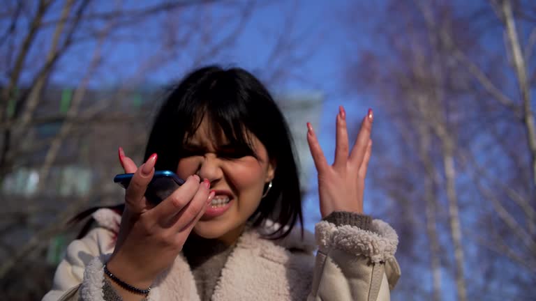 Portrait angry young woman screaming on mobile phone  on the street. Negative human emotions feelings.