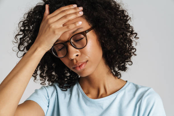 istock Black curly woman in eyeglasses with headache holding her forehead 1458534049