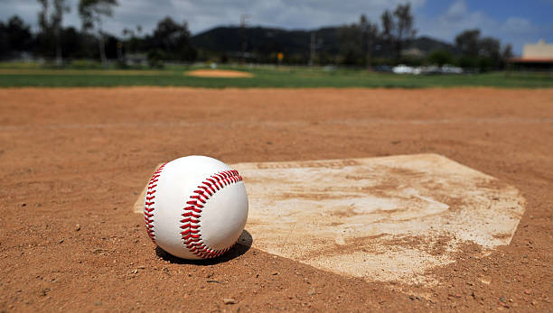 Time For Baseball A baseball near home plate with ballpark in background. youth baseball and softball league photos stock pictures, royalty-free photos & images