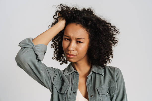 istock Black young woman holding her head while looking at camera 1458536063