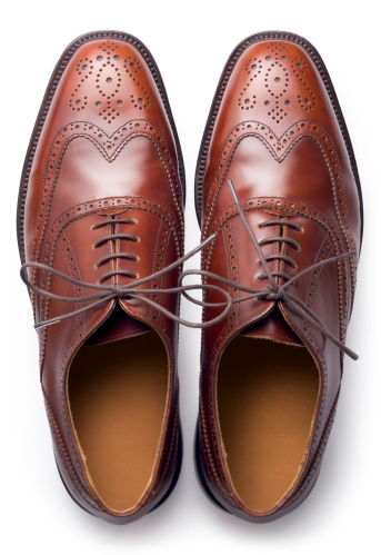 A pair of men's traditional brown shoes isolated on white and shot from above