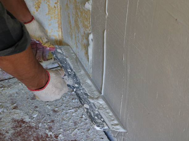 istock plastering the wall with a wide trowel and elastic putty 1458536384