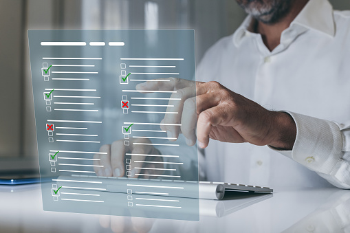 Man do online exam on virtual screen. Answer a survey filling out a tech form. Quiz, test concept.