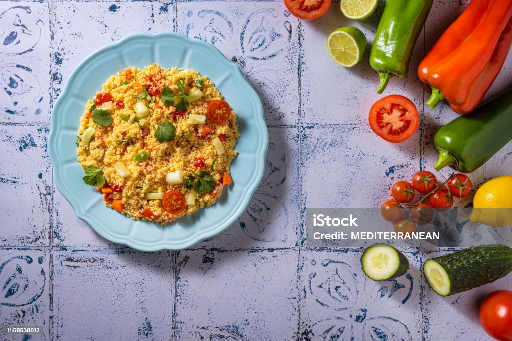 Tabouli, tabouleh salad recipe with tomatoes, pepper and cucumbers Tabouli, tabouleh salad recipe with tomatoes, pepper and cucumbers with ingredients on mediterranean white tiles table Appetizer Stock Photo