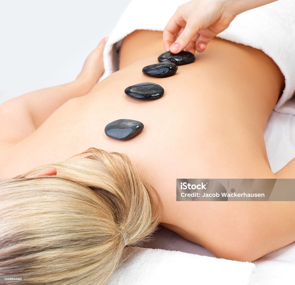 Masajes con piedras calientes de una mujer joven - Foto de stock de 20 a 29 años libre de derechos