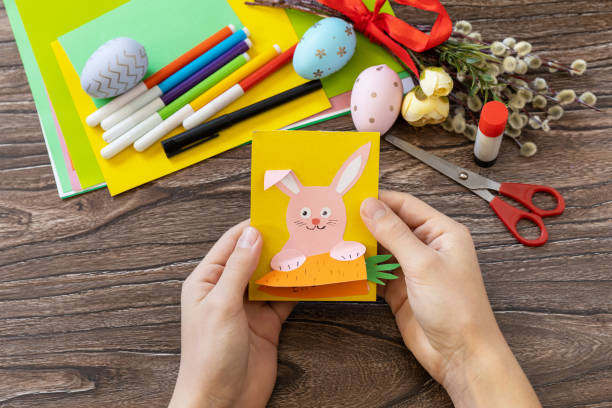 istock A child is holding an Easter congratulation card with Easter bunny. Handmade. Project of children's creativity, handicrafts, crafts for kids. 1458544872