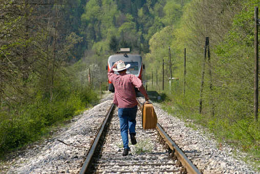 Man in western style is running to catch the train.
