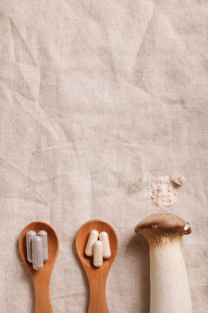 istock mushroom and natural herbal pills on wood spoons on textile background. environmental friendly , healthy, medical supplement concept. copy space. 1458546607